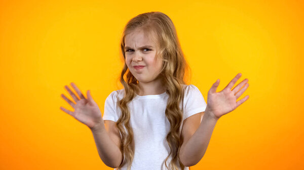 Недовольная школьница машет руками, не рекомендуя низкого качества образования
