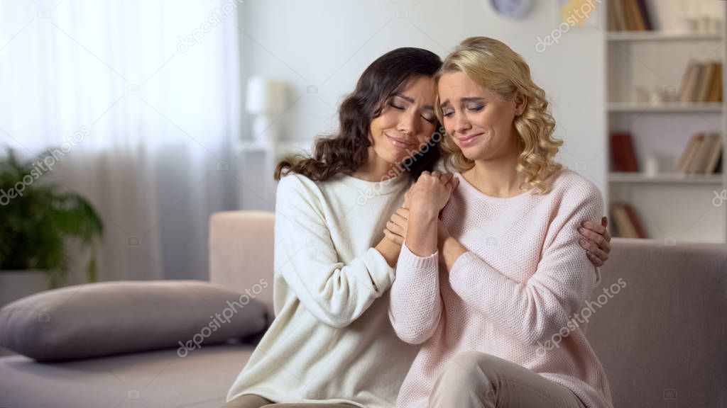 Young woman hugging and reconciling with female friend after quarrel indoors