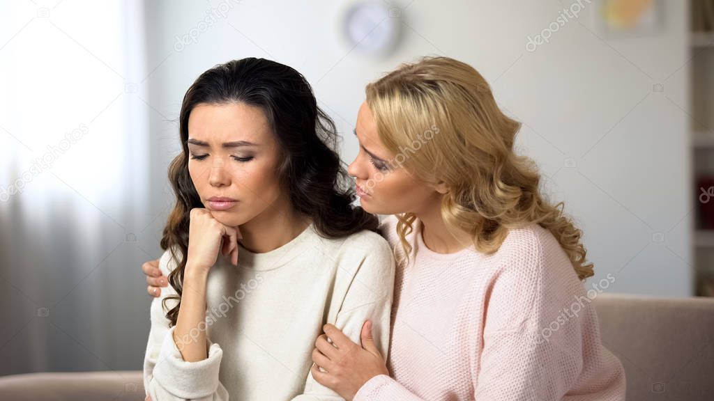 Woman hugging and supporting depressed friend, braking up with boyfriend