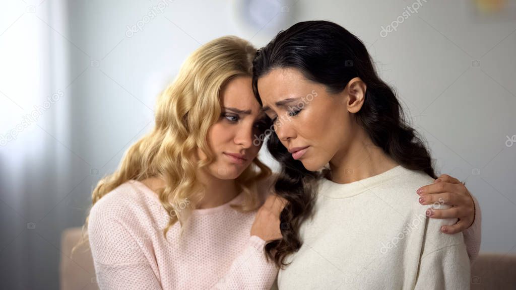 Female hugging and supporting her depressed friend, incurable health disease