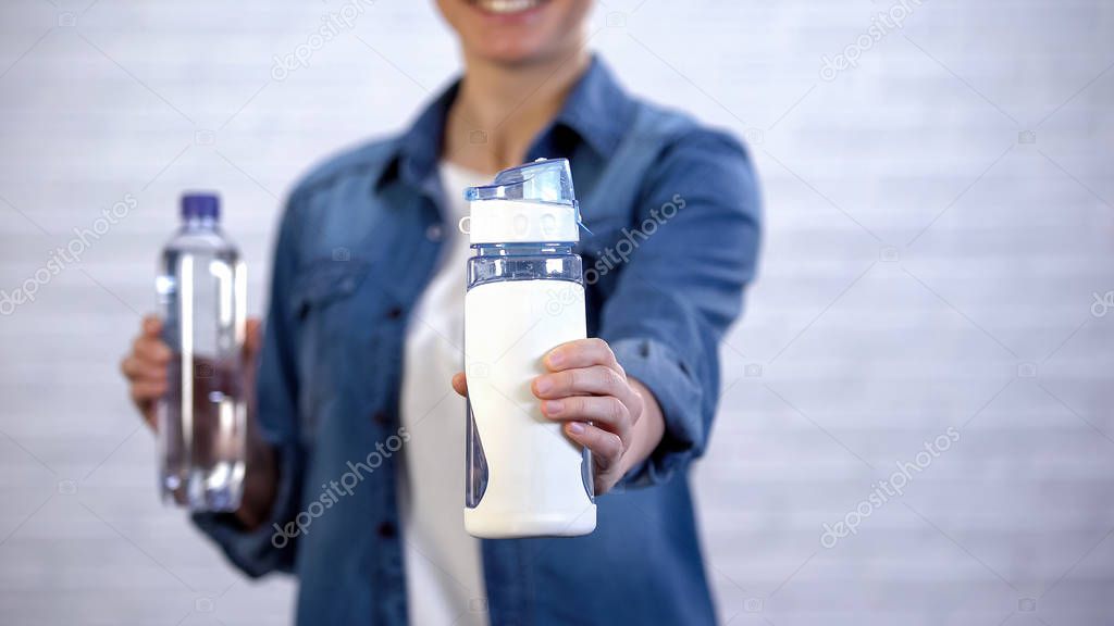 Female choosing reusable thermos instead disposable bottle, plastic pollution