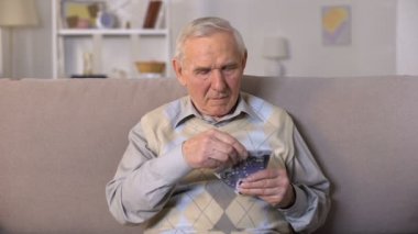 Üzgün yaşlı adam kanepede oturan, Euro banknotlar tutarak, sosyal güvensizlik