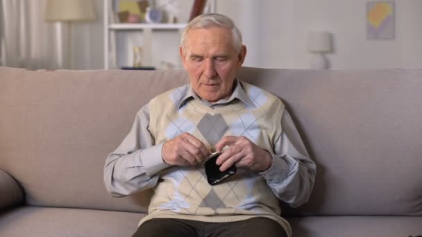 슬픈 노인 소파에 앉아 카메라에 빈 지갑을 보여주는, 빈곤 — 비디오