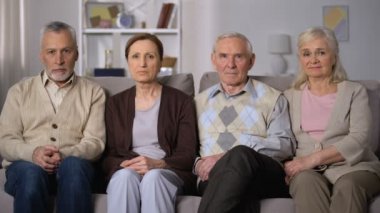 Üzgün kıdemli arkadaşlar kanepede oturan ve kamera bakarak, sosyal sorunlar