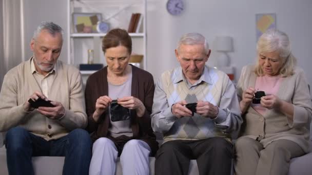 Missnöjda äldre människor som söker i tomma plånböcker, brist på pengar, konkurs — Stockvideo