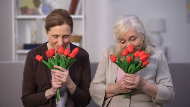 Sonriendo ancianas oliendo ramo de tulipanes, feliz día de las madres, presente — Vídeos de Stock