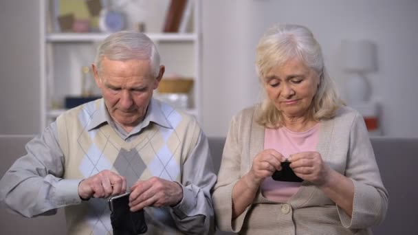 Upset aged couple showing empty wallets into camera, social reform needing — Stock Video