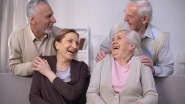 Neşeli eski çiftler gülüyor ve evde birlikte iyi vakit geçiriyor, dostluk