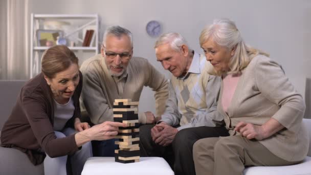 Активные пожилые люди играют в блокигры, проводят время в дружеской атмосфере — стоковое видео