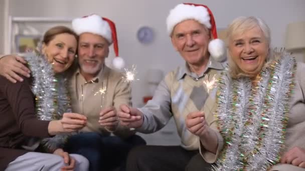 Leende oldsters i nyår kostymer innehar Sparklers, julfirande — Stockvideo