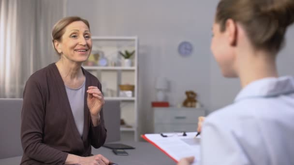 Mujer madura sinceramente regocijándose escuchando buenas noticias sobre su salud del médico — Vídeo de stock