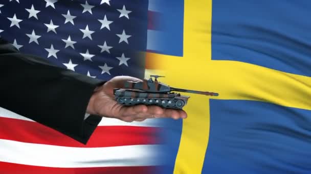 Stati Uniti e Svezia funzionari che scambiano carri armati per denaro, commercio di armi, sfondo bandiera — Video Stock