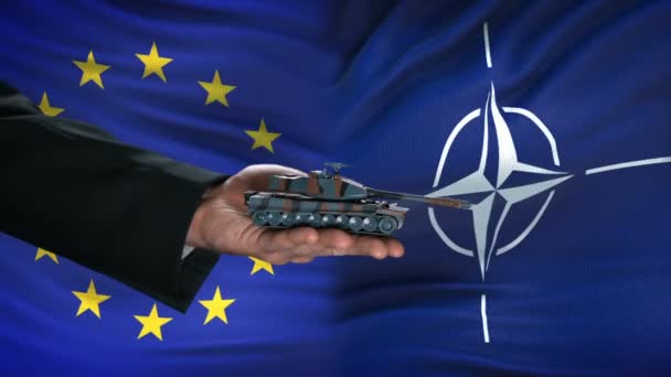 BRUSSELS, BELGIUM - CIRCA JUNE 2019: EU and NATO officials exchanging tank for money, flag background, agreement — Stock Video