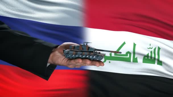 Rusland en Irak ambtenaren uitwisselen van tank voor geld, wereldwijde armen vlag achtergrond — Stockvideo