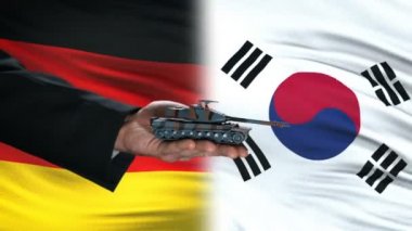 Almanya ve Güney Kore yetkilileri para için tank alışverişi, bayrak arka plan