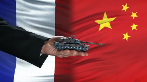 Frankrijk en China ambtenaren uitwisselen van tank voor geld, vlag achtergrond, verdediging — Stockvideo