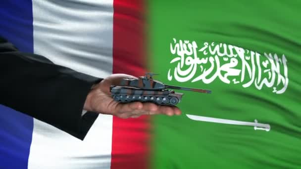 França e Arábia Saudita funcionários trocando tanque por dinheiro, fundo da bandeira — Vídeo de Stock