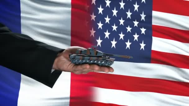 France and USA officials exchanging tank for money, flag background, agreement — Stock Video