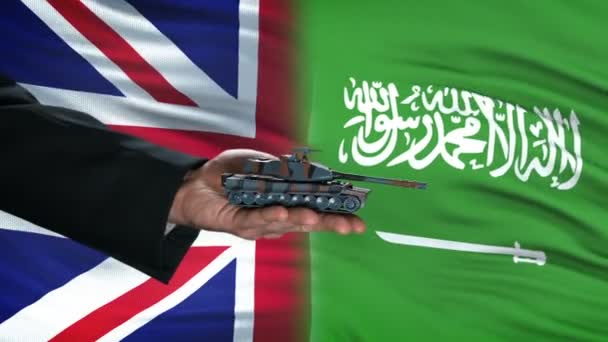 Große britische und saudi-arabische Beamte tauschen Panzergeld aus, Hintergrund der Flagge — Stockvideo