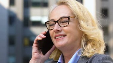 Olumlu yaşlı politikacı telefonla iş tartışıyor, mobil müzakereler