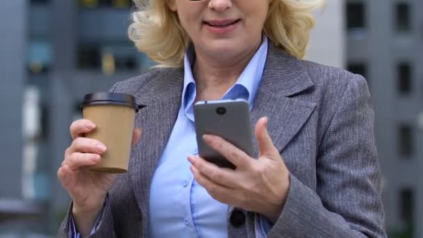Heyecanlı iş kadını kahve içerken cep telefonu iyi bir uygulama wow söyleyerek — Stok video