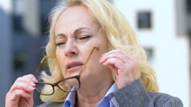 Yoğun iş gününden sonra migreni olan yaşlı kadın, stresli iş