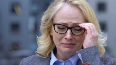 Depresif yaşlı kadın çalışan umutsuzca ağlıyor, işten kovuldu ya da emekli