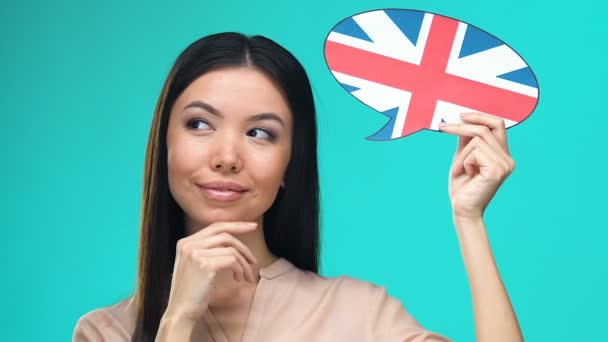 Dreaming pretty female holding English speech bubble, fluent foreign language — Stock Video