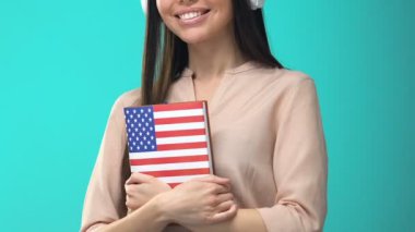 Mutlu kız öğrenci kulaklık Amerikan kitap, online seminer, bilgi tutan