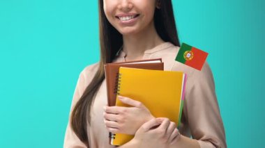 Portekiz ceretomlarında dizüstü bilgisayarlar tutan, yabancı dil öğrenen neşeli genç kadın