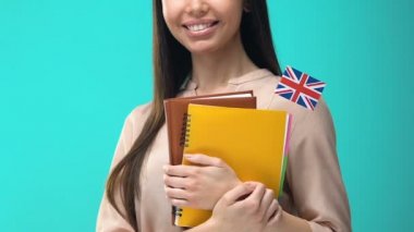 İngiliz bayrağı defterleri tutan neşeli genç kadın, dil okulu, kurs