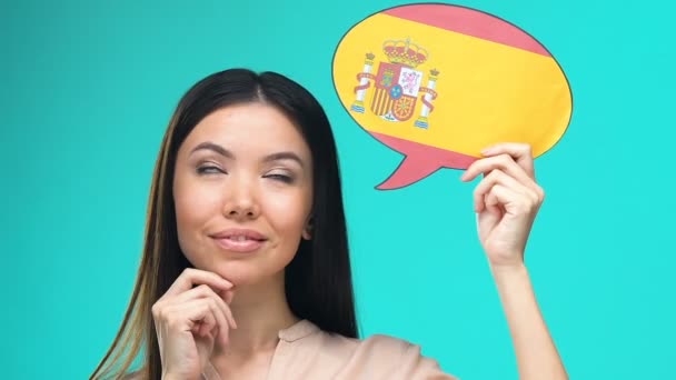 Dreaming pretty female holding Spanish speech bubble, fluent foreign language — Stock Video