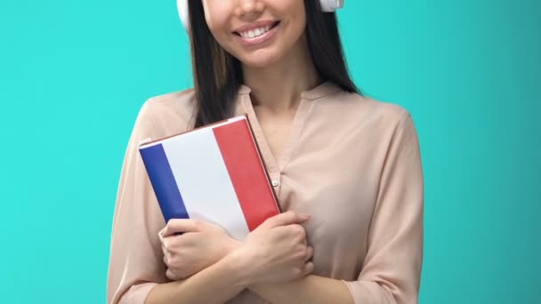 Joyeuses étudiantes écouteurs tenant livre français, séminaire en ligne, connaissances — Video