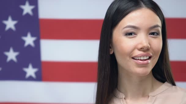 미국 국기 배경, 송금에 신용 카드를 보여주는 매력적인 여자 — 비디오