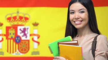 İspanyol bayrağı arka plan, öğrenci değişimi karşı gülümseyen defterleri ile kadın