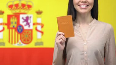 Mutlu bayan pasaport gösteren, İspanyol bayrağına karşı duran, vatandaşlık alma