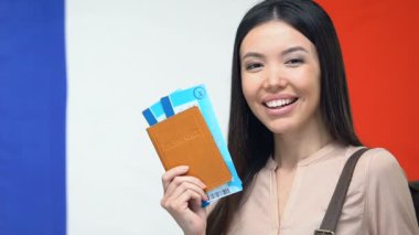 Mutlu turist bilet ile pasaport gösteren, Fransa'ya seyahat, rüya gezisi