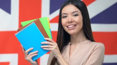 Asyalı kadın İngiltere bayrağı, yabancı öğrenciler için burs karşı copybooks gösteren