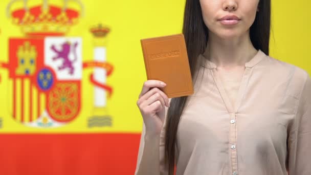 Senhora séria mostrando passaporte, isolado em fundo bandeira espanhola, eleição — Vídeo de Stock