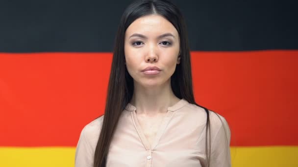 Serious woman showing passport, German flag background, relações internacionais — Vídeo de Stock