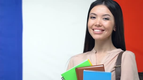 Estudiante sonriente con copybooks, fondo de la bandera francesa, educación en Francia — Vídeos de Stock