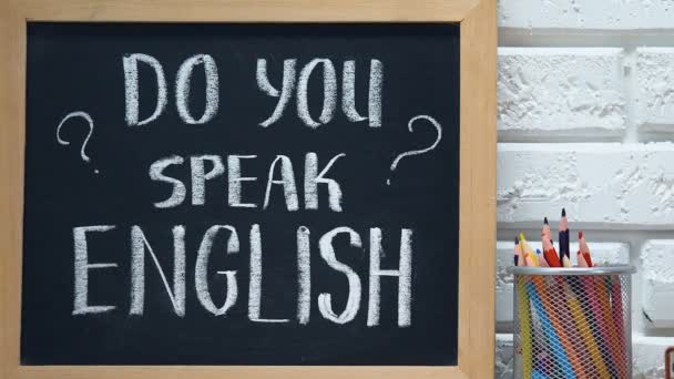 Você fala Inglês no quadro negro, bandeira nacional no copo da caneta, escola de idiomas — Vídeo de Stock