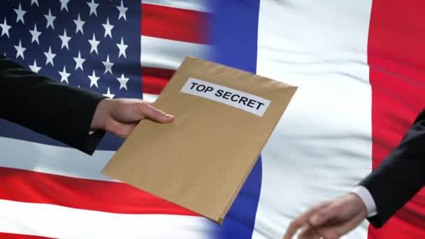 Politiker aus den USA und Frankreich tauschen streng geheime Umschläge aus, Flaggen im Hintergrund — Stockvideo