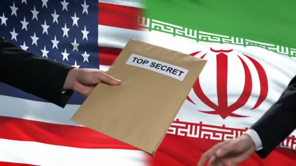 USA und iranische Politiker tauschen streng geheime Umschläge aus, Flaggen im Hintergrund — Stockvideo
