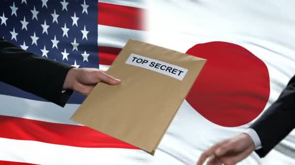 Estados Unidos y Japón políticos intercambian sobres de alto secreto, banderas de fondo — Vídeos de Stock