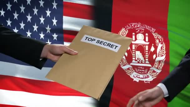 アメリカとアフガニスタンの政治家が極秘封筒を交換、旗の背景 — ストック動画