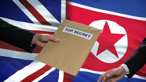 Great Britain and North Korea politicians exchanging top secret envelopes, flags — Stock Video