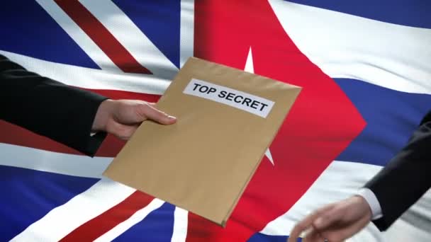 Great Britain and Cuba politicians exchanging top secret envelopes against flags — Stock Video