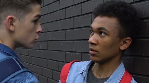 Agressieve blanke tiener die Afro-Amerikaanse kerel, racisme en geweld bedreigt — Stockvideo
