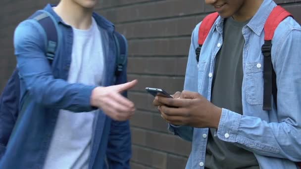 Agressieve Kaukasische tiener grijpen Afro-Amerikaanse klasgenoten telefoon, problemen — Stockvideo